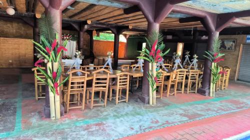 un restaurante con sillas de madera, mesas y flores en Echodi San José Roman 