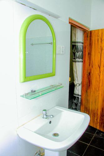 a bathroom with a white sink and a mirror at Mahee Villa & Ayurvedic Spa in Dambulla