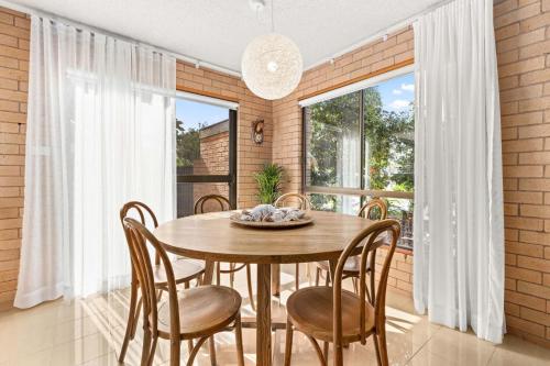 a dining room with a wooden table and chairs at Samos by Experience Jervis Bay in Huskisson