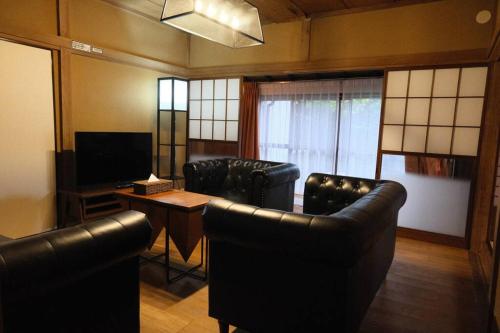 a living room with leather chairs and a television at 12月NEWOPEN 鎌倉House 響 ペットと泊まれる北鎌倉4LDK貸別荘 in Yamanouchi
