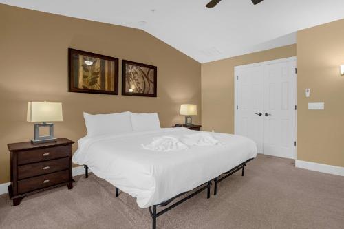 - une chambre avec un grand lit blanc et deux lampes dans l'établissement 4BR. Disney World Vacation Townhome, à Orlando