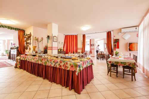 une grande chambre avec deux tables et de la nourriture dans l'établissement Hotel Fabbrini, à Abbadia San Salvatore