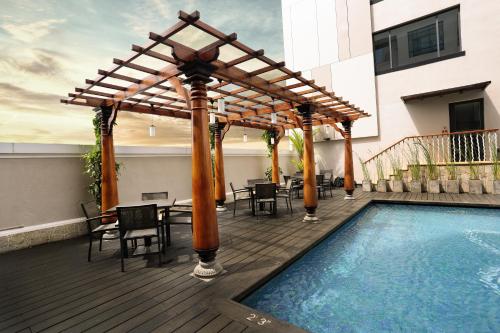a wooden deck with a pergola and a swimming pool at Hilton Garden Inn, Trivandrum in Trivandrum
