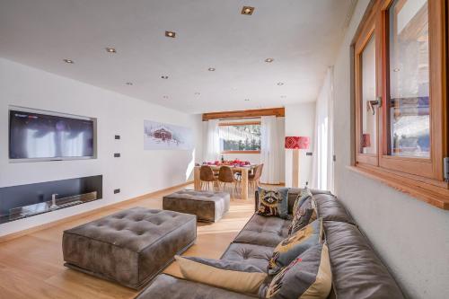 a living room with a couch and a tv at Chalet Merveille Ski In - Ski Out - Happy Rentals in Sauze dʼOulx