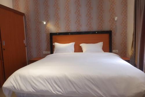 a large white bed with two pillows in a bedroom at Agape Hotel Haranggaol in Haranggaul