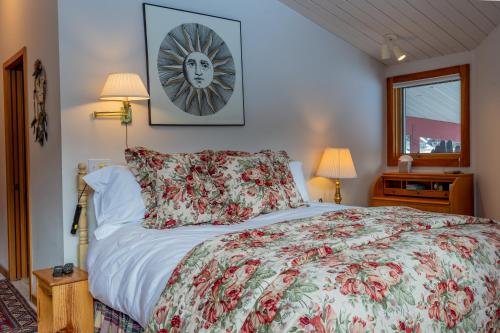 1 dormitorio con 1 cama con colcha de flores en Baldy View Home - Amazing Hillside Home Close to Warm Springs Lifts, en Ketchum