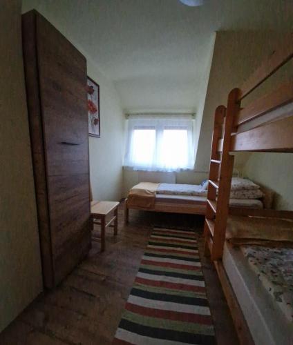 a bedroom with two bunk beds and a window at Silver Zsóry Apartman II. in Mezőkövesd
