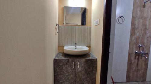 a bathroom with a sink on a counter with a mirror at UDUPI G01 HOMESTAY in Udupi