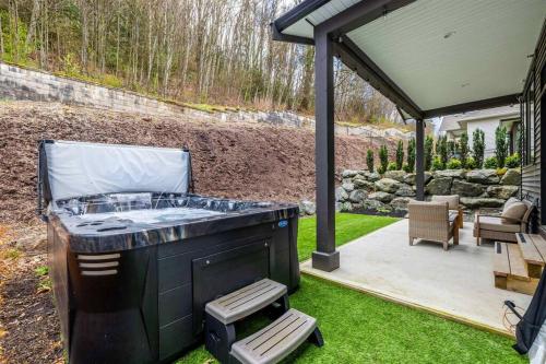 a barbecue in a backyard with a gazebo at Mountain Retreat with Views, Hot Tub, Games & AC in Chilliwack