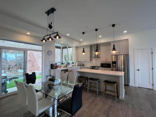 a kitchen with a glass table and some chairs at Mountain Retreat with Views, Hot Tub, Games & AC in Chilliwack