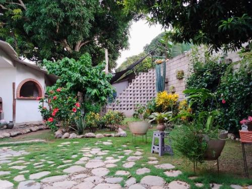 un jardin avec un chemin en pierre en face d'une maison dans l'établissement Hermoso Palomino, à Palomino