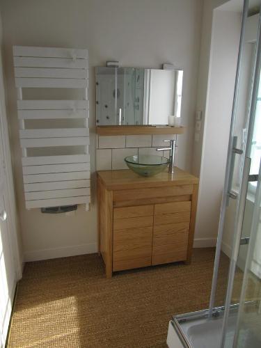 ein Badezimmer mit einem Glaswaschbecken auf einer Holzkommode in der Unterkunft Suite Sainte Anne in Beaumont-sur-Sarthe