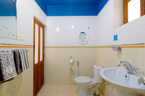 a bathroom with a toilet and a sink at Skylark Resort in Colva