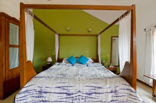 a bedroom with a large bed with blue pillows at Skylark Resort in Colva