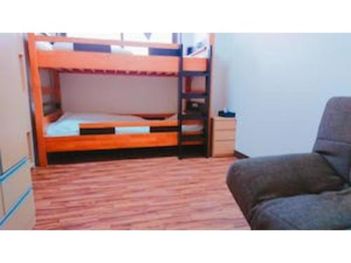 1 dormitorio con litera y sofá en The Stay Central Nagasaki / Vacation STAY 5111, en Nagasaki