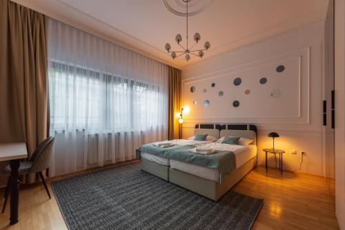 a bedroom with a bed and a table and a desk at Sarajevo Central Elegance Apartments in Sarajevo