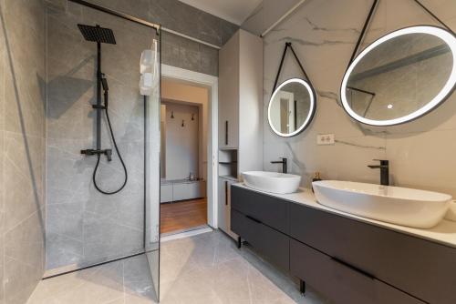 a bathroom with two sinks and a shower at Sarajevo Central Elegance Apartments in Sarajevo