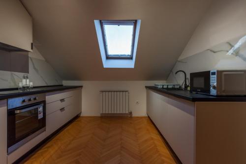 a kitchen with a microwave oven and a window at Sarajevo Central Elegance Apartments in Sarajevo