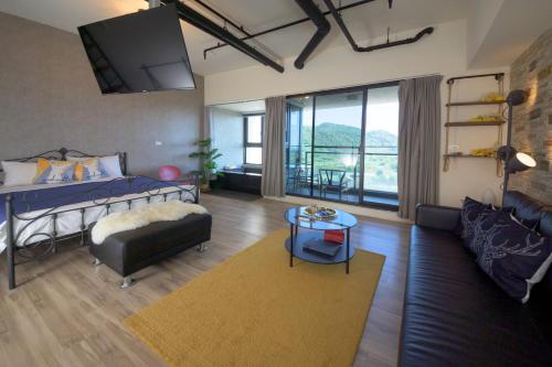 sala de estar con cama y sofá en Yilan A Happy Apartment, en Hsin-hsing