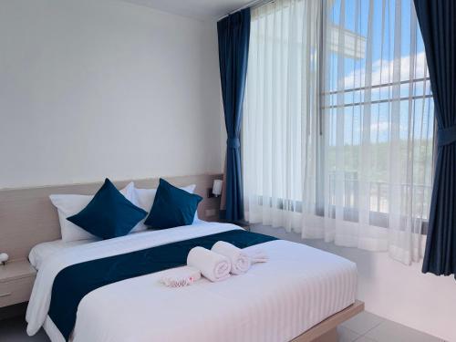 2 Betten in einem Hotelzimmer mit Handtüchern darauf in der Unterkunft White Seaview Residence in Klong Muang Beach
