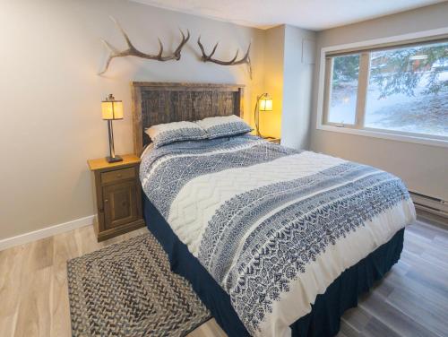 En eller flere senge i et værelse på 2 Bedroom and Wall Bed Mountain Getaway Ski In Ski Out Condo with Hot Pools Sleeps 8
