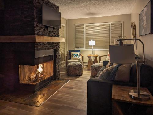a living room with a fireplace and a couch at 2 Bedroom and Wall Bed Mountain Getaway Ski In Ski Out Condo with Hot Pools Sleeps 8 in Panorama