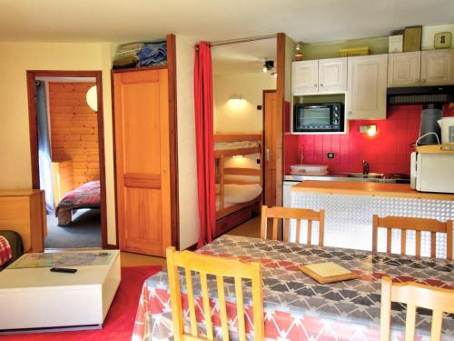 une petite cuisine avec une table et des chaises dans une pièce dans l'établissement Appartement cosy 2 pièces, proche centre Morzine, balcon, parking, animaux admis - FR-1-524-24, à Morzine