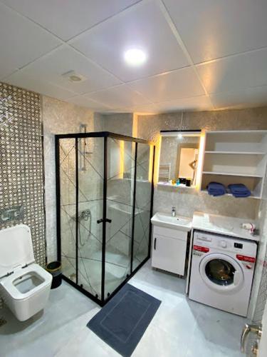 ein Badezimmer mit einem WC und einer Waschmaschine in der Unterkunft Clock Towers Life in Balıkesir