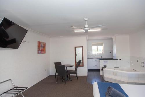 sala de estar con mesa y bañera en Matilda Motor Inn, en Dubbo