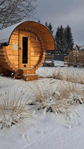 a wooden cabin with a door in the snow at Słoneczna Sielanka domki w Bieszczadach in Ustrzyki Dolne