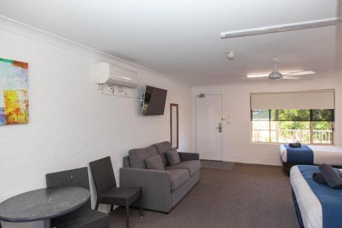 a living room with a couch and a table at Matilda Motor Inn in Dubbo