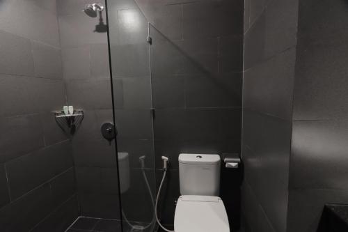 a bathroom with a shower with a toilet in it at Golden Tulip Essential Makassar in Makassar
