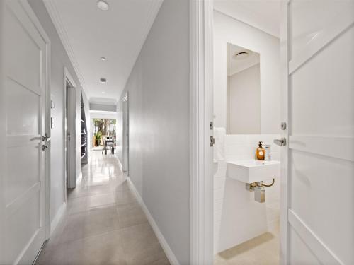a white hallway with a sink and a mirror at Park View in Margaret River Town