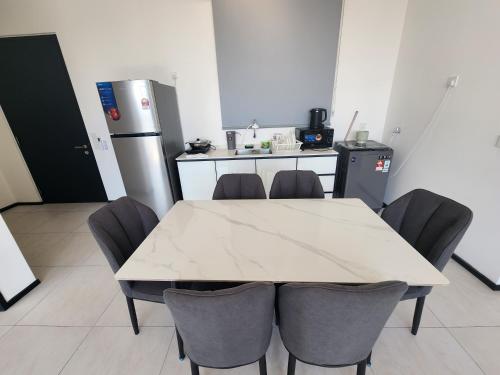 a kitchen with a table and chairs and a refrigerator at Urban Suite - George Town in Jelutong