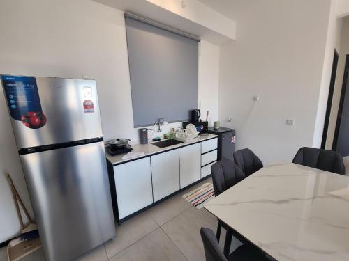 a kitchen with a stainless steel refrigerator and a table at Urban Suite - George Town in Jelutong