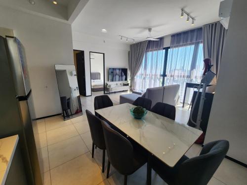 a dining room and living room with a table and chairs at Urban Suite - George Town in Jelutong