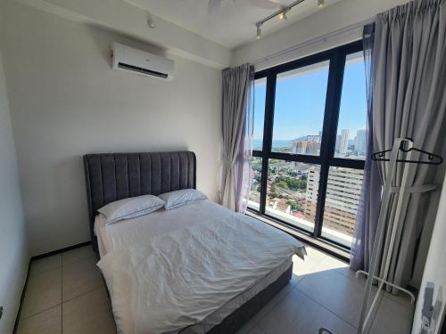 a bedroom with a bed and a large window at Urban Suite - George Town in Jelutong