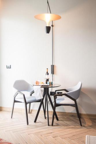 a dining room table with two chairs and a lamp at Almond Hotel - Adults only in Neve Ilan