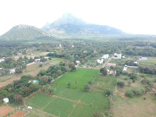 an aerial view of a field with mountains in the background at RPM home stay in Tiruvannāmalai