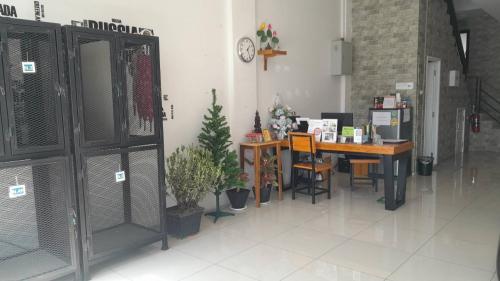 バンコクにあるSleepy and Homey Don Mueang Airport Hostelのデスク、テーブル、椅子が備わる客室です。