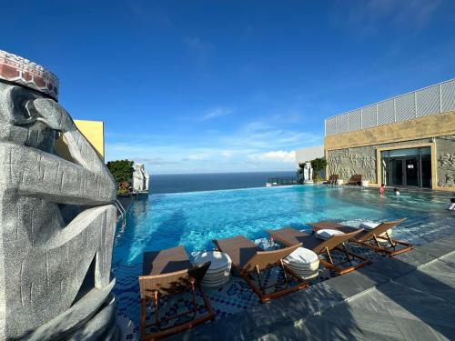 綏和的住宿－Tony Apartment - Apec Mandala Phú Yên，一个带躺椅和雕像的游泳池