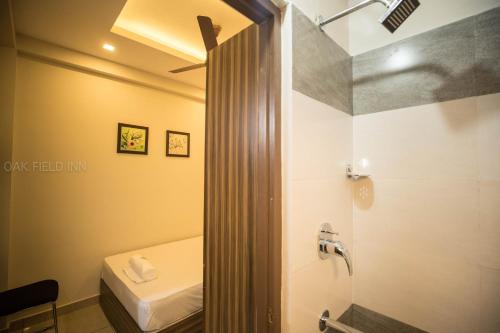 a bathroom with a shower with a toilet and a sink at Oak Field Inn in Cochin