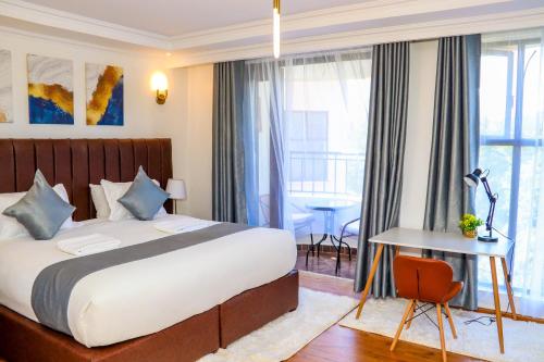 ein Hotelzimmer mit einem Bett, einem Tisch und einem Schreibtisch in der Unterkunft Sangara by Edmor Suites in Nairobi