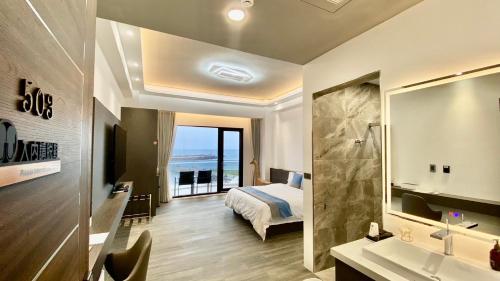 a hotel room with a bed and a bathroom at 愛琴海岸精品民宿 in Fangliao