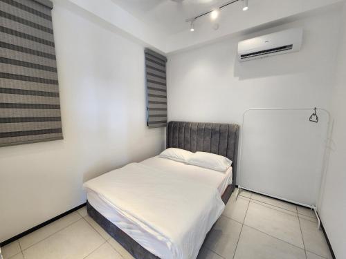 a small bedroom with a bed and a window at Urban Suites - Penang in Jelutong