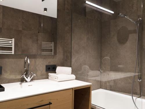 a bathroom with a shower and a sink and a tub at Apartment in Schröcken near Ski Arlberg in Schröcken