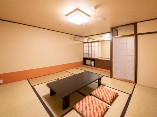 a room with a table and a chair in it at Yuzanso in Otsu