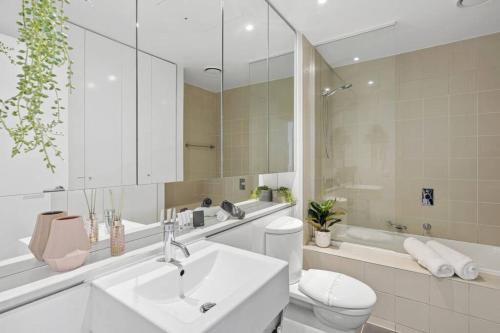 a bathroom with a sink and a toilet and a mirror at Ultimate Comfort Gem in St Kilda in Melbourne