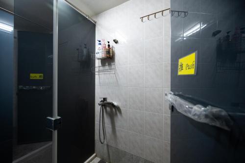 ein Bad mit einer Dusche und einem Waschbecken in der Unterkunft Carlos Backpacker in Minxiong