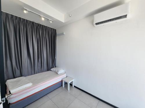 a small bed in a room with a curtain at Urban Suites - Penang in Jelutong